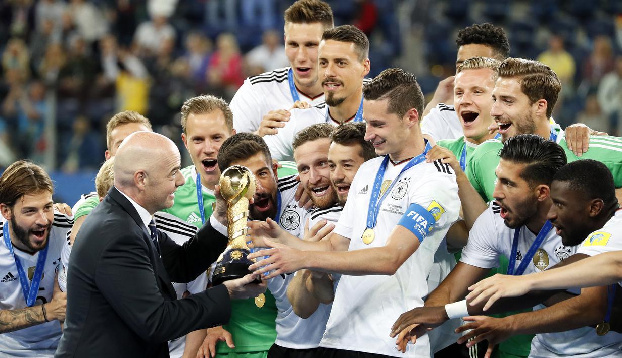 Presiden FIFA, Gianni Infantino, menyerahkan trofi Piala Konfederasi 2017 kepada kapten Jerman, Julian Draxler di Stadion Saint Petersburg, Rusia, Minggu (3/7/2017). Jerman menang 1-0 atas Cile. (EPA/Yuri Kochetkov)
