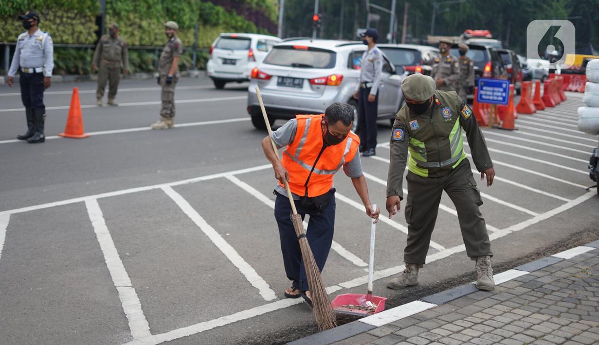 Petugas gabungan menghukum warga saat Operasi Yustisi Protokol Covid-19 di kawasan Tugu Tani, Jakarta, Senin (14/9/2020). Operasi tersebut digelar sebagai langkah untuk menekan penyebaran Covid-19 di masa PSBB Jakarta. (Liputa6.com/Immanuel Antonius)