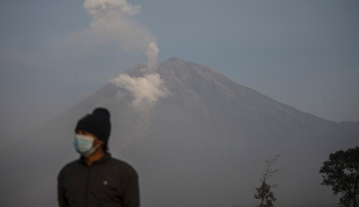 Asap mengepul dari Gunung Semeru di Lumajang (5/12/2022). Gunung Semeru meletus pada tanggal 4 Desember memuntahkan awan abu panas setinggi satu mil dan sungai lava di sisinya sambil memicu evakuasi hampir 2.000 orang tepat satu tahun setelah letusan besar terakhirnya menewaskan puluhan orang. (AFP/Juni Kriswanto)