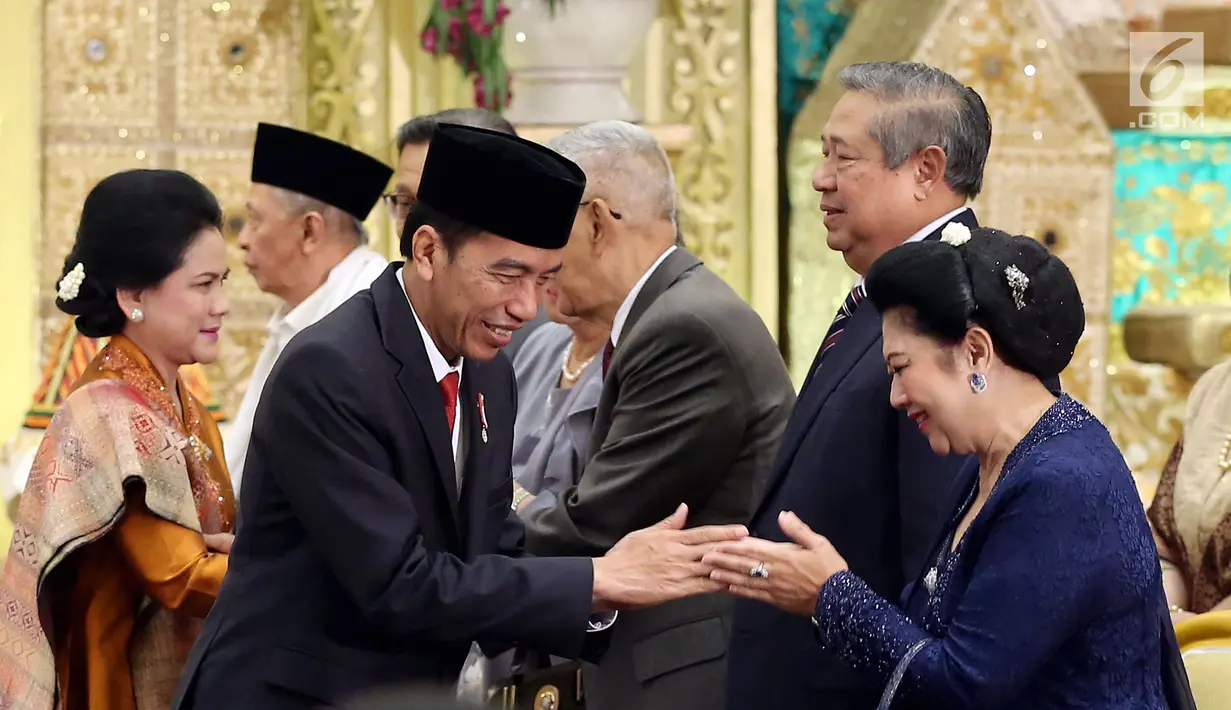 Presiden Joko Widodo didampingi Ibu Negara, Iriana bersalaman dengan Presiden keenam RI Susilo Bambang Yudhoyono dan istri Ani Yudhoyono pada resepsi pernikahan putri Ketua DPD, Oesman Sapta Odang di Jakarta, Jumat (8/9). (Liputan6.com/Johan Tallo)