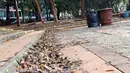 Ceceran daun kering terlihat menumpuk di area Taman Puring yang berada di kawasan Jakarta Selatan, Minggu (15/9/2019). Nampak kondisi taman memprihatinkan, sejumlah bagian taman terlihat rusak dan kotor. (Liputan6.com/Helmi Fithriansyah)