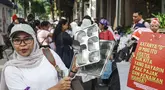 Seorang perempuan memukul peralatan dapur saat melakukan protes menuntut pemerintah meninjau kembali program Makan Bergizi Gratis (MBG), menurunkan harga Bahan Bakar Minyak (BBM), dan membuka lebih banyak lapangan kerja bagi perempuan, di Jakarta, Kamis 18 Juni 2026. (BAY ISMOYO/AFP)