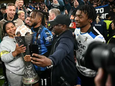 Pemain Atalanta, Ademola Lookman (tengah) merayakan gelar juara Liga Europa 2023/2024 bersama keluarganya setelah laga final melawan Bayer Leverkusen di Dublin Arena, Irlandia, Kamis (23/05/2024) dini hari WIB. (AFP/Paul Ellis)