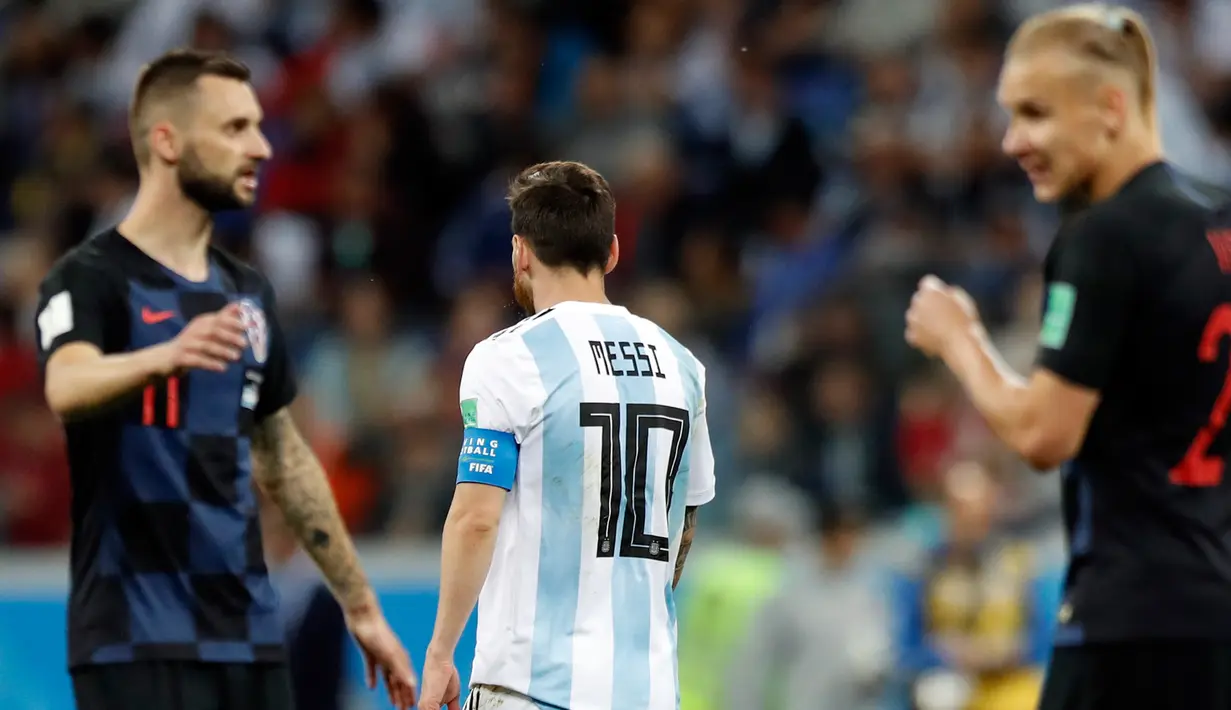 Kapten timnas Argentina, Lionel Messi meninggalkan lapangan ketika pemain Kroasia merayakan kemenangan pada pertandingan Grup D Piala Dunia 2018 di Nizhy Novgorod Stadium, Jumat (22/6). Argentina harus mengakui keunggulan Kroasia 0-3. (AP/Pavel Golovkin)
