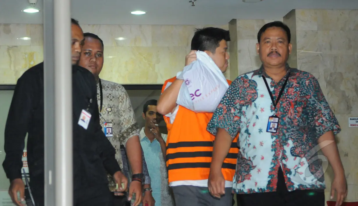 Andrew Hidayat berusaha menghindari kamera wartawan saat keluar dari gedung KPK usai menjalani pemeriksaan, Jakarta, Sabtu (11/4/2015), dini hari. Andrew ditangkap KPK bersama barang bukti uang senilai  US$ 90.000. (Liputan6.com/Herman Zakharia)