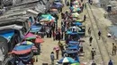 Warga memadati jalan yang dipenuhi lapak pedagang di area pasar tradisional selama karantina wilayah masih diberlakukan pemerintah setempat di Dhaka, Bangladesh (12/5/2020). (AFP/Munir Uz Zaman)