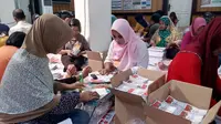 Tenaga lepas di kantor KPU Kota Malang melipat dan menyortir surat suara Pilkada serentak 2018 (Liputan6.com/Zainul Arifin)