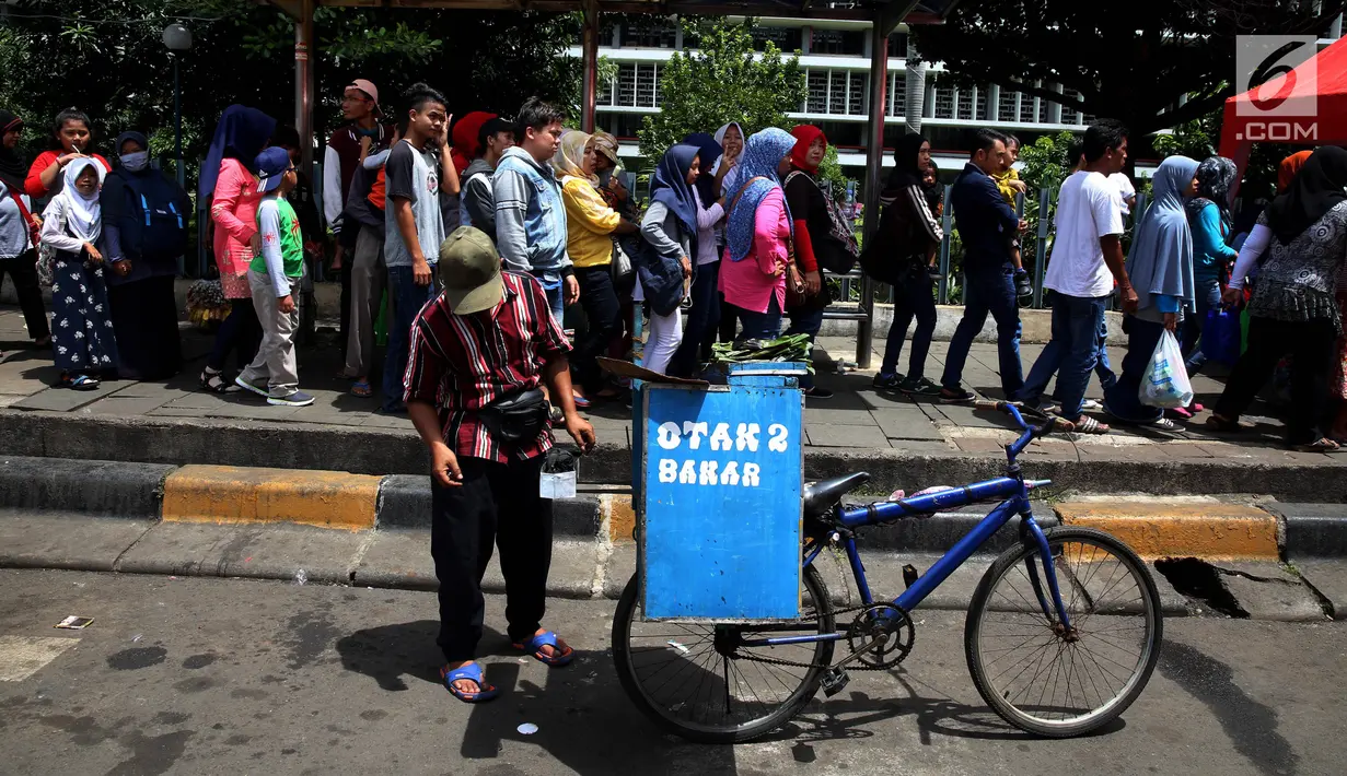 Pedagang otak-otak memanfaatkan libur tahun baru dengan berjualan di kawasan Kota Tua, Jakarta Selasa (2/1). Suasana libur tahun baru dimanfaatkan wisatawan dari berbagai daerah berwisata di ibukota Jakarta. (Liputan6.com/Johan Tallo)