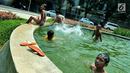 Sejumlah anak mandi bermain di bundaran air mancur Jalan Teuku Umar, Jakarta Pusat, Sabtu (23/9). Cuaca panas ibu kota memaksa anak-anak menceburkan diri di kolam untuk menyejukkan badan. (Liputan6.com/Helmi Afandi)