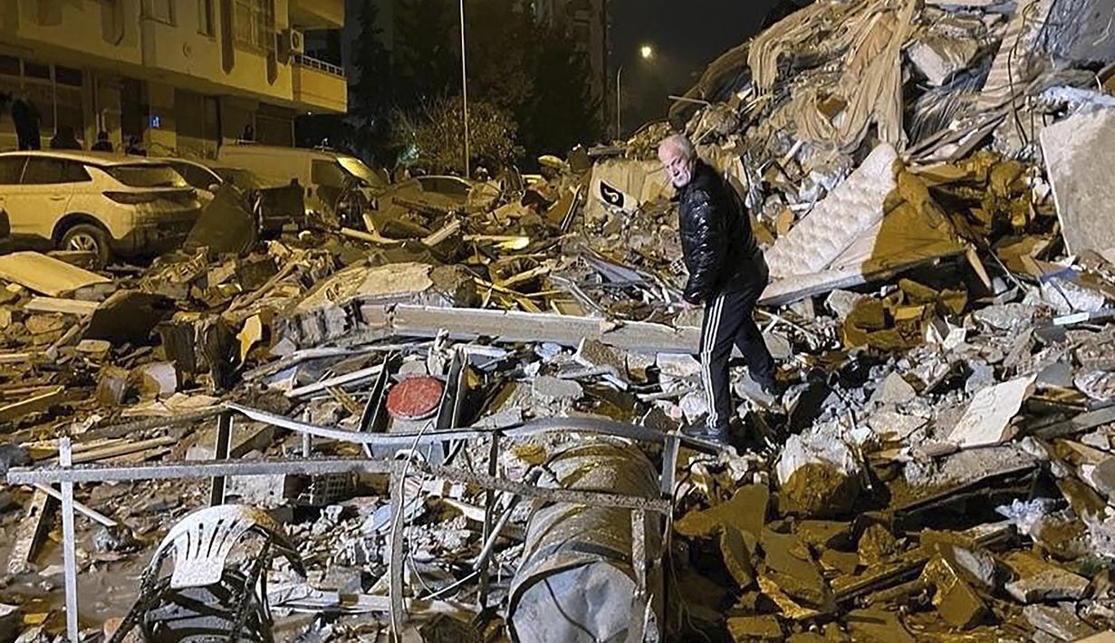 Seorang pria mengecek bangunan yang runtuh di Diyarbakir, Turki selatan, Senin dini hari, 6 Februari 2023. Laporan The Guardian, Senin (6/1/2023) menyebut, sedikitnya 10 orang tewas di Turki setelah gempa mengguncang selatan negara itu dan juga Suriah utara, kata dua pejabat Turki. (Depo Photos via AP)