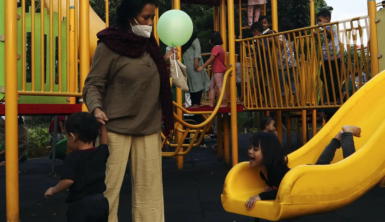Anak-anak didampingi orangtua bermain di RPTRA Bhineka Jakarta Selatan, Sabtu (30/7/2022). Selain menjadi alternatif mengisi libur bersama keluraga, taman juga menjadi ruang bagi warga untuk berinteraksi sosial sekaligus mengeduksi anak untuk bermain bersama teman-teman dengan wahana yang tersedia. (Liputan6.com/Johan Tallo)