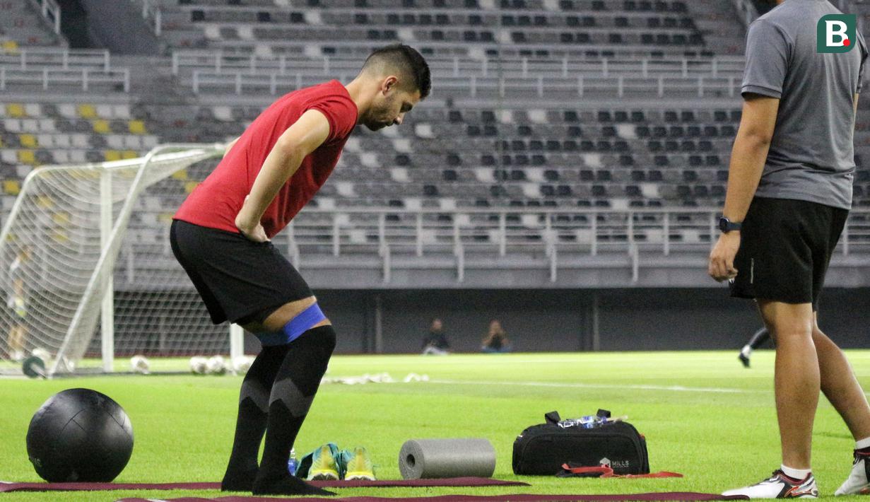 Pemain naturalisasi Timnas Indonesia, Sandy Walsh, melakukan peregangan otot dibagian paha saat menjalani latihan terpisah di Stadion Gelora Bung Tomo (GBT), Surabaya, Sabtu (10/6/2023) petang WIB. (Bola.com/Wahyu Pratama)