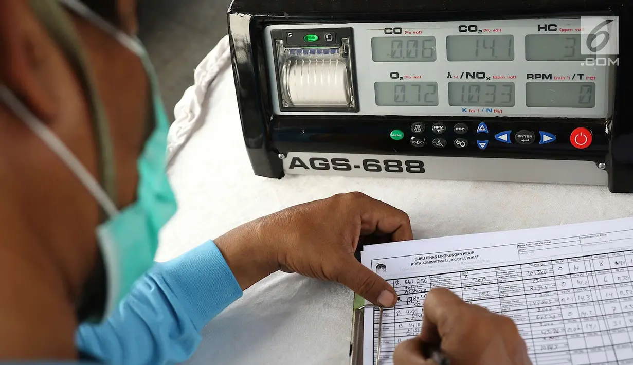 Petugas sudin lingkungan hidup mengisi form uji emisi gas buang kendaraan di kawasan Senayan, Jakarta, Rabu (18/7). Dinas Lingkungan Hidup bersama intansi terkait juga akan menerapkan sistem elektronik uji emisi. (Liputan6.com/Immanuel Antonius)