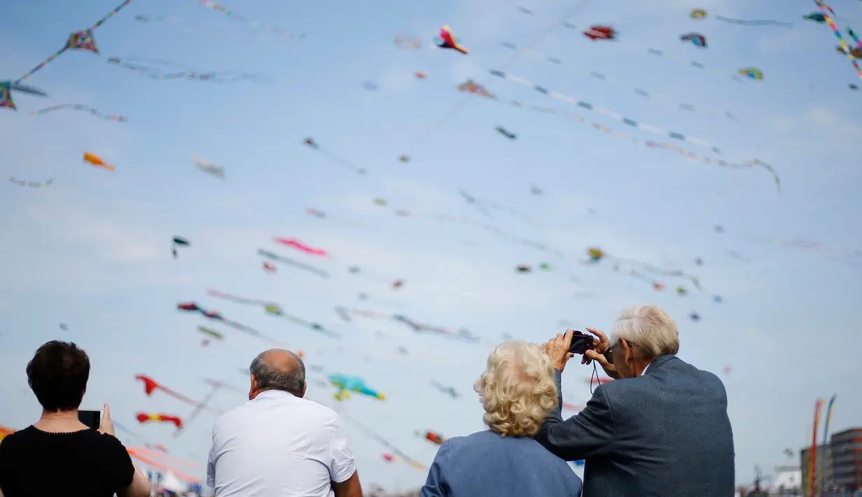 Orang-orang mengambil gambar selama Festival Layang-layang Internasional Dieppe ke-20 di Dieppe, Prancis, Minggu (9/9). Festival setiap dua tahun sekali sejak 1980 itu merupakan salah satu festival layang-layang terbesar di dunia. (AFP/CHARLY TRIBALLEAU)