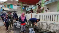 Rawan Mirza, Pjs. Area Manager Karaha memimpin langsung kegiatan beberesih desa dengan membersihkan saluran air warga yang berada di jalan desa Sukahurip, Garut, Jawa Barat (Liputan6.com/Jayadi Supriadin)