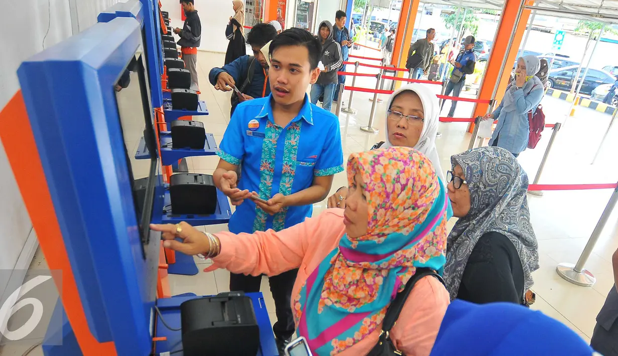 Petugas membantu calon penumpang melakukan transaksi di mesin penjual tiket di Stasiun Senen, Jakarta, Selasa (20/12). Jelang libur Natal dan tahun baru tiket Kereta Api sudah habis untuk keberangkatan Jateng dan Jatim. (Liputan6.com/Angga Yuniar)