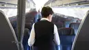 Pramugari Bette Nash memeriksa kursi penumpang sebelum melakukan penerbangan ke Boston di Bandara Ronald Reagan Washington di Arlington, Virginia (19/21). Bette Nash adalah pramugari tertua  yang kini berusia 81 tahun. (AFP Photo/Eric Baradat)
