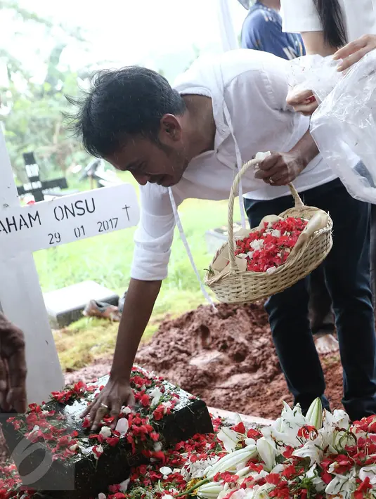 Artis Ruben Onsu menangis sambil menabur bunga di atas makam sang ayah, Johannes Abraham Onsu di TPU Pondok Ranggon, Jakarta Timur, Rabu (1/2). Ayah Ruben dan Jordi Onsu meninggal pada hari Minggu, 29 Januari malam. (Liputan6.com/Herman Zakharia)