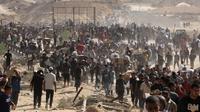 Warga Palestina yang mengungsi berkumpul untuk menerima bantuan dari titik distribusi bantuan GHF di koridor Netzarim, Jalur Gaza tengah pada 30 Juli 2025. (Eyad BABA/AFP)