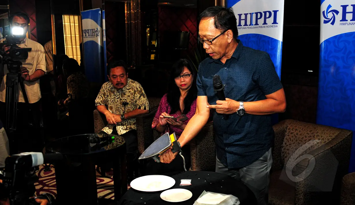 Pakar Kimia dari Universitas Indonesia (UI) Dr. Asmo Wahyu (tengah) menunjukkan cara membedakan beras asli dengan beras palsu dengan cara di setrika terkait maraknya kasus beredarnya beras plastik, Jakarta, Jumat (21/5/2015). (Liputan6.com/Yoppy Renato)
