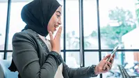 Seorang wanita bahagia saat melihat ponselnya. (Odua/depositphotos.com)