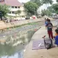 Suasana di bantaran anak Sungai Ciliwung, Jakarta, Rabu (6/6). Meskipun tidak layak sebagai tempat bermain, namun lokasi itu menjadi tempat bagi anak-anak di kawasan tersebut untuk menunggu waktu berbuka. (Liputan6.com/Immanuel Antonius)