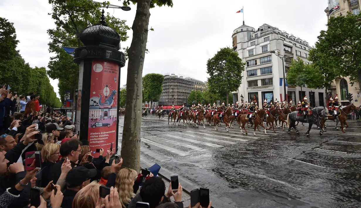 Suasana arak-arakan Presiden terpilih Prancis Emmanuel Macron saat berparade di jalan Champs Elysees usai upacara peresmian sebagai Presiden Prancis, Paris, Minggu (14/5). (AFP PHOTO / CHARLY TRIBALLEAU)