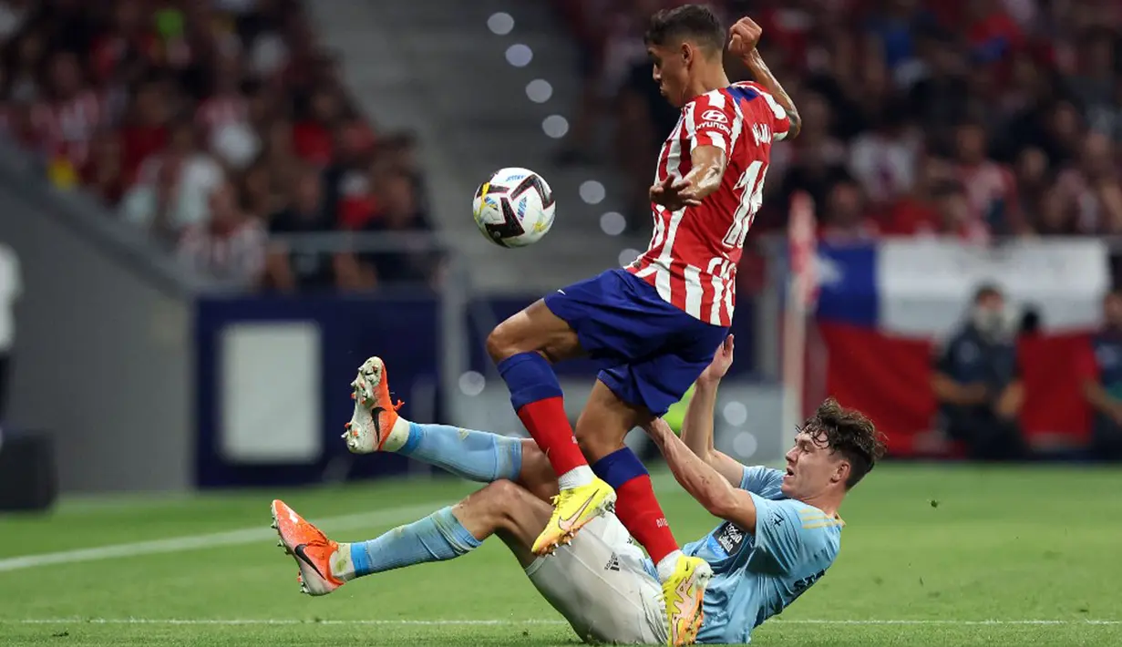 Pemain Atletico Madrid Nahuel Molina (atas) berebut bola dengan pemain Celta Vigo Orbelin Pineda pada pertandingan sepak bola Liga Spanyol di Stadion Wanda Metropolitano, Madrid, Spanyol, 10 September 2022. Atletico Madrid menang 4-1. (Thomas COEX/AFP)