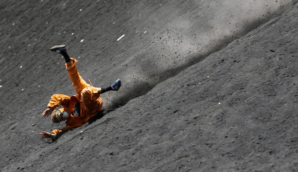 Seorang wisatawan terjatuh ketika bermain sandboarding atau berseluncur pasir menuruni gunung berapi Cerro Negro di Leon, Nikaragua, 24 September 2016. Gunung Cerro Negro salah satu gunung api yang masih aktif di Nikaragua. (INTI Ocon/AFP)
