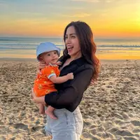 Hilangkan stres usai kena tipu Rp10 Miliar, Jessica Iskandar dan keluarga kecilnya pergi berlibur ke Bali. Intip potret penampilannya saat ajak Baby Don perdana ke pantai. (Instagram/inijedar).