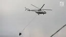 Helikopter water bombing membawa air untuk disiramkan ke arah ban yang dibakar massa di kawasan Slipi, Jakarta, Rabu (22/5/2019). Air dijatuhkan dari udara ke arah api yang berasal dari ban bekas. (merdeka.com/Imam Buhori)