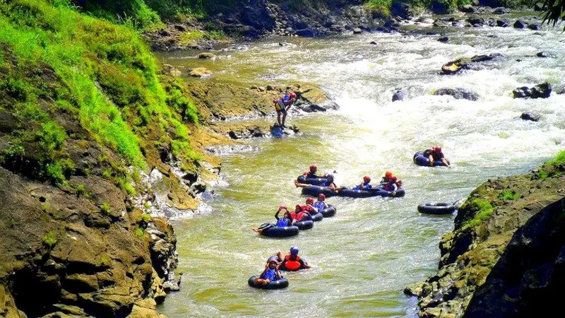 Tubing menyusuri derasnya aliran sungai Klawing. (Liputan6.com/Dinkominfo PBG/Muhamad Ridlo)