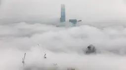 Bangunan tempat tinggal yang diselimuti kabut dan Pusat Perdagangan Internasional (ICC di atas) di Hong Kong, Selasa (22/3/2022). Kabut tebal menyelimuti Hong Kong pada musim semi ketika wilayah tersebut dipengaruhi oleh udara dingin dan hangat bergantian. (AFP/Dale De La Rey)