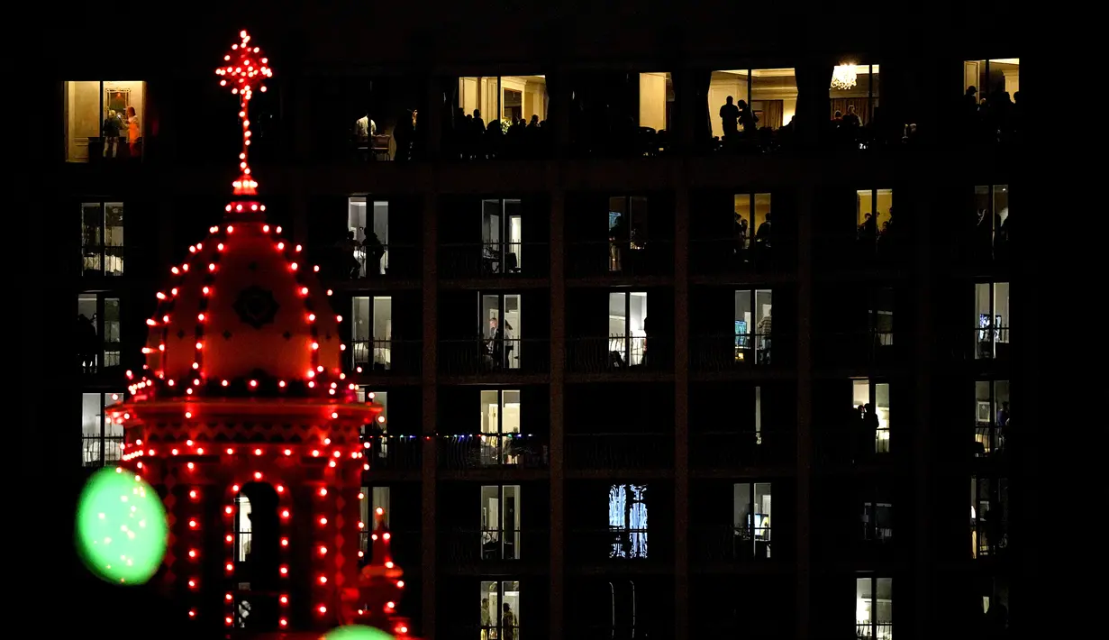 Orang-orang menonton lampu Natal dinyalakan di distrik perbelanjaan Country Club Plaza, Kansas City, Missouri, Amerika Serikat, 25 November 2021. Upacara ini telah menjadi tradisi selama lebih dari 90 tahun di pusat perbelanjaan menandai awal musim belanja Natal. (AP Photo/Charlie Riedel)