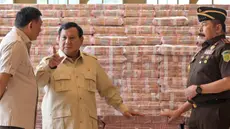 Presiden Prabowo Subianto (tengah) berbicara dengan Jaksa Agung Sanitiar Burhanuddin (kanan) dan Menteri Pertahanan Indonesia Sjafrie Sjamsoeddin di samping tumpukan uang kertas rupiah Indonesia senilai 800 juta USD di gedung Kejaksaan Agung Republik Indonesia, Jakarta, Senin 20 Oktober 2025. (BAY ISMOYO/AFP)
