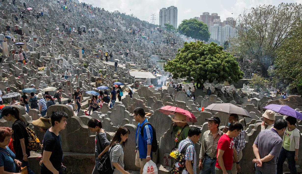 Warga mengunjungi makam keluarga dan kerabat selama festival Qingming di pemakaman di Hong Kong (5/4). Festival Qingming atau dikenal sebagai Hari Pembersihan Makam untuk menghormati orang yang dicintainya yang telah tiada. (AFP Photo/Isaac Lawrence)
