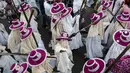 Eyo masqueraders berjalan menyusuri jalan menuju Tafawa Balewa Square di Lagos, Nigeria (20/5). Para peserta yang berpakaian putih ini mewakili roh orang mati yang disebut Yoruba atau "agogoro Eyo". (AFP Photo/Stefan Heunis)