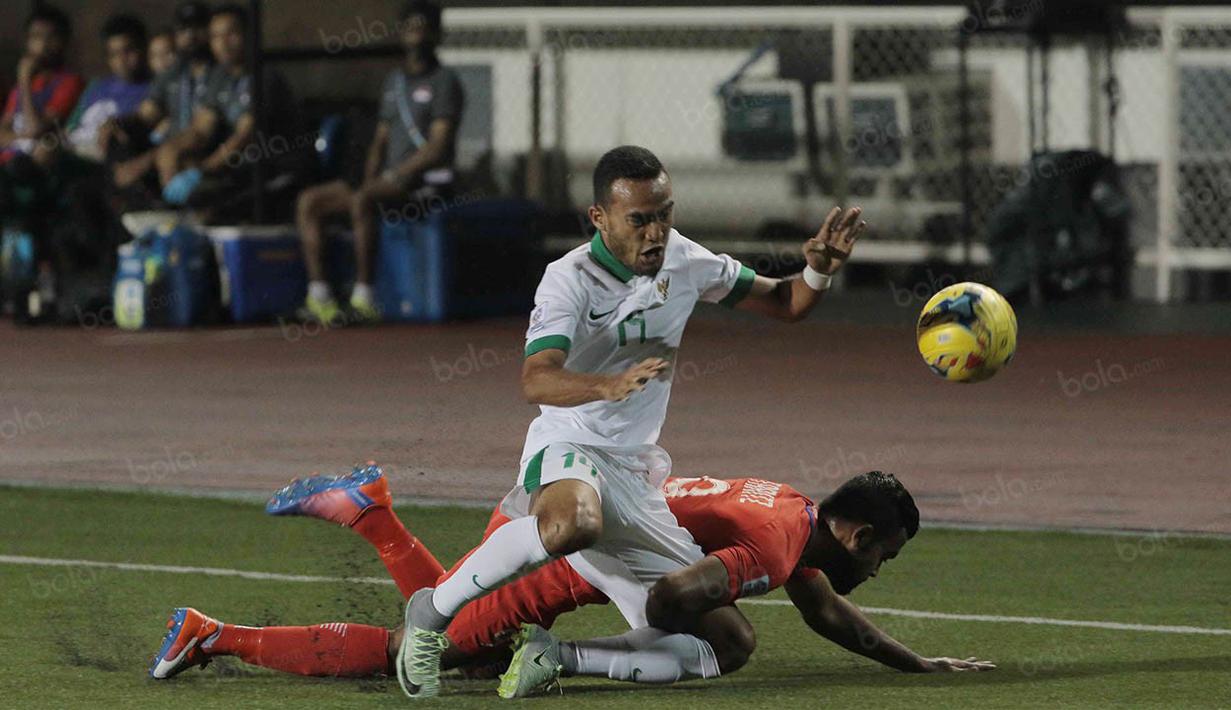Gelandang Timnas Indonesia, Rizky Pora, terjatuh saat berebut bola dengan pemain Singapura pada laga Piala AFF 2016 di Filipina, Jumat (25/11/2016). Indonesia tertinggal 0-1 dari Singapura. (Bola.com/Nicklas Hanoatubun)