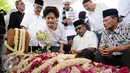 Gubernur Banten, Rano Karno (kedua kanan duduk) terduduk usai pemakaman ibunya, Lily Soekarno M Noor di TPU Tanah Kusir Jakarta, Senin (7/12/2015). Ibunda Rano Karno wafat di usia 77 tahun akibat komplikasi penyakit. (Liputan6.com/Helmi Fithriansyah)