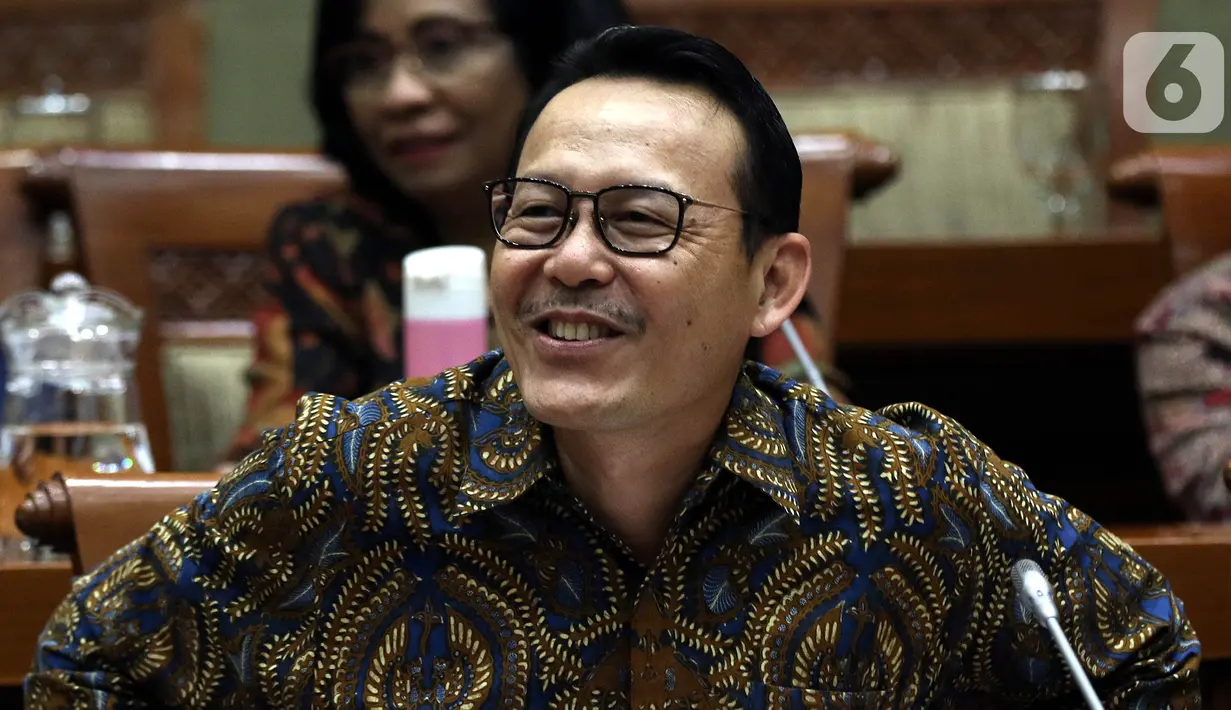 Dirut BPJS Kesehatan Fachmi Idris tertawa saat rapat dengar pendapat dengan Komisi IX DPR di Kompleks Parlemen, Jakarta, Selasa (5/11/2019). Rapat membahas polemik kenaikan iuran BPJS Kesehatan. (Liputan6.com/JohanTallo)