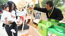 Warga melihat produk-produk pertanian yang dipamerkan pada pembukaan acara perayaan untuk menandai festival panen petani China di Distrik Pinggu, Beijing, ibu kota China, pada 24 September 2020. (Xinhua/Ren Chao)