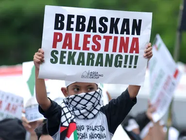 Massa membentangkan tulisan saat berunjuk rasa di depan Kedubes AS Jalan Medan Merdeka Selatan, Jakarta, Selasa (3/4). Aksi ini dukungan moral kepada rakyat Palestina yang ingin pulang ke tanah kelahiran. (Liputan6.com/Helmi Fithriansyah)