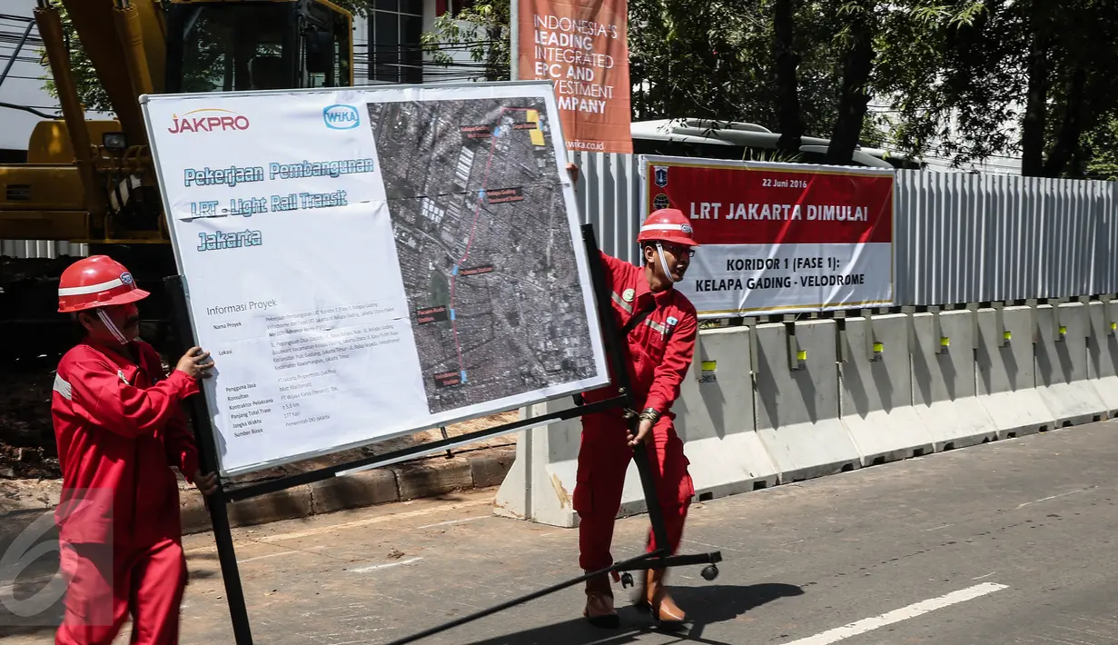 Pekerja membawa spanduk proyek Light Rail Transit (LRT) Velodrome di kawasan Rawamangun, Jakarta, Rabu (22/6).Prioritas pembangunan dengan rute Kelapa Gading-Veledrome-Rawamangun. (Liputan6.com/Faizal Fanani)