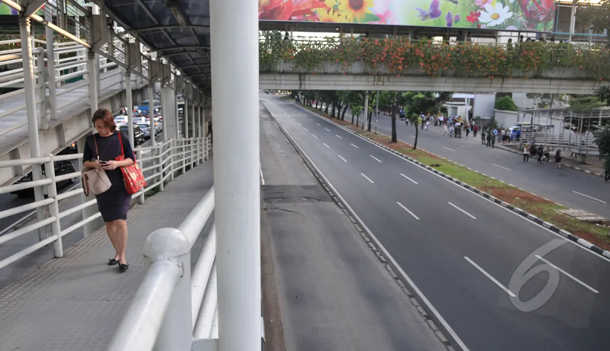 Sejumlah penumpang Transjakarta Rute Blok-M – Kota terpaksa berjalan kaki karena rute ditutup sementara terkait pengalihan arus, Jakarta, Rabu (22/4/2015). Pengalihan arus dilakukan untuk kelancaran acara KAA.(Liputan6.com/Johan Tallo)