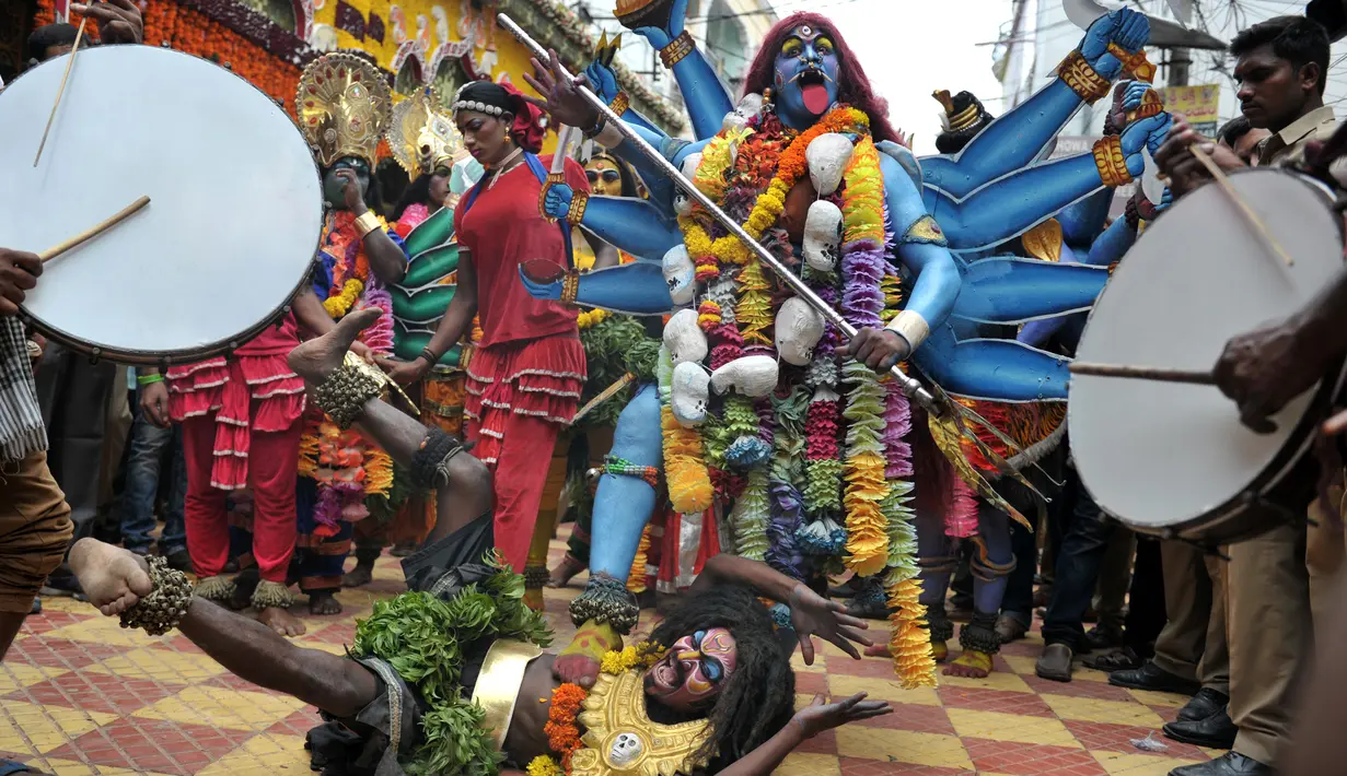 Seorang seniman India berpakaian seperti dewi Hindu Mahakali saat tampil dalam festival tradisional 'Bonalu' di Kuil Sri Ujjaini Mahankali, India (10/7). Festival Bonalu ini selalu digelar setiap tahunnya di Telangana. (AFP Photo/Noah Seelam)
