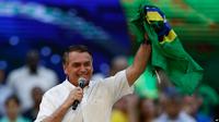 Presiden Brasil Jair Bolsonaro memegang bendera negara Brasil dalam acara peluncuran kampanyenya untuk maju kembali dalam pemilihan presiden Brasil. Acara tersebut digelar di Rio de Janeiro, Brasil, pada 24 Juli 2022. (Foto: AP/Bruna Prado)