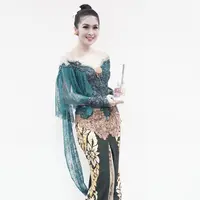 Kebaya modern model off shoulder dipadukan dengan rok batik dengan detail high slit buat Sandra Dewi makin elegan. [@sandradewi88]