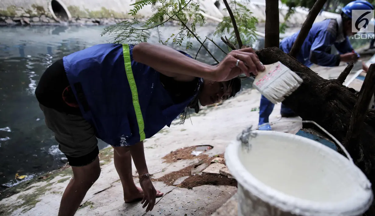 Petugas Suku Dinas Tata Air melakukan pengecatan bantaran Kali Gresik, Menteng, Jakarta, Minggu (29/10). Kali Gresik juga disebut sistem drainase Menteng adalah kali percontohan di Ibu Kota untuk tidak membuang sampah di kali. (Liputan6.com/Faizal Fanani)