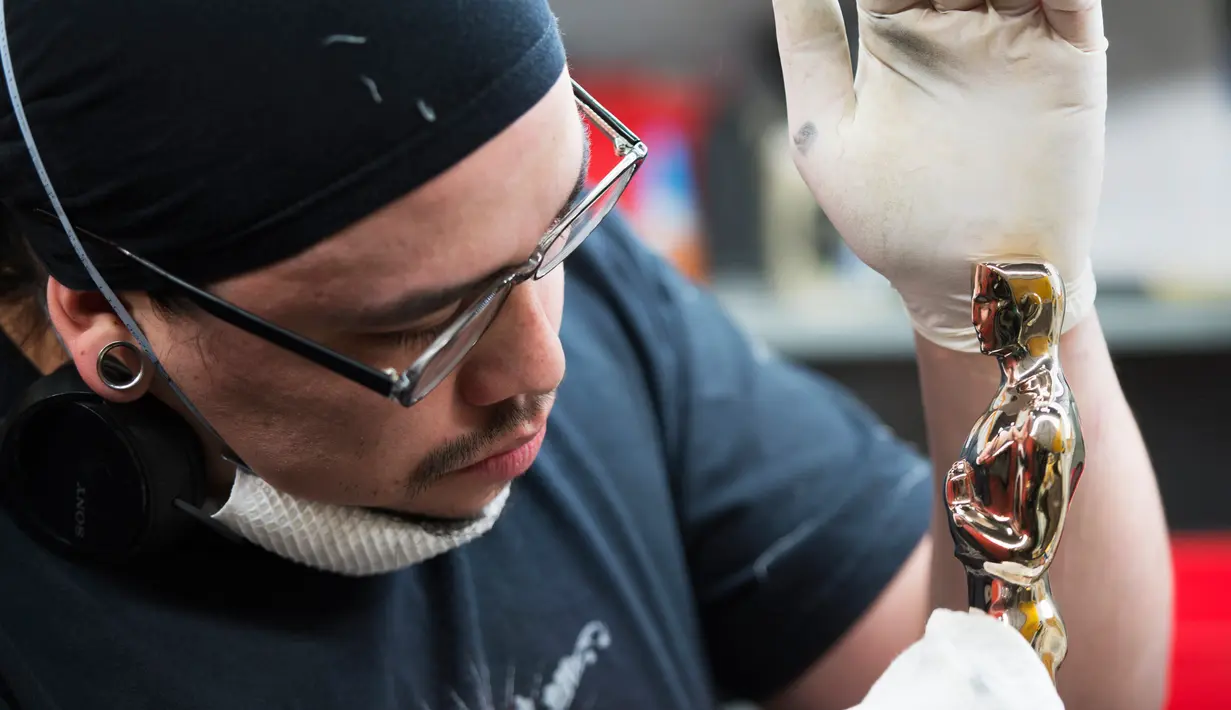 Leo Sotelo memoles Piala Oscar di tempat produksi Polich Tallix Fine Art Foundry, New York, AS (13/1). Kelima jari-jari tersebut melambangkan aktor, sutradara, produser, teknisi, dan penulis yang semua itu terkait dalam produksi film. (AFP/Don Emmert)