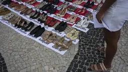 Di sepanjang Pantai Copacabana, pengunjuk rasa memasang 722 pasang sepatu perempuan, mulai dari sepatu hak tinggi hingga sepatu kets. (Tercio TEIXEIRA / AFP)